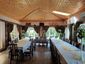 a row of tables in a room with windows at Noclegi Pod Dębem, Pulandia Brzózki in Brzózki