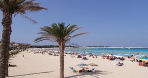 a group of people on a beach with palm trees at Appartamento LG in San Vito lo Capo