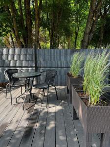eine Terrasse mit Tisch und Stühlen und einem Zaun in der Unterkunft Izabelės apartamentai. Butas - studija in Palanga