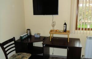uma mesa com uma garrafa de vinho e um copo de vinho em Deers em Bansko
