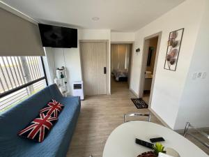 a living room with a blue couch and a table at Suite Nueva en Salinas - Chipipe, en conjunto privado in Salinas