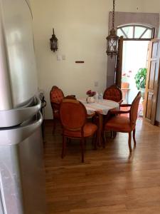 a dining room with a table and chairs and a refrigerator at Hotel del Vasco in Zacatecas