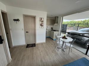 a kitchen and a dining room with a table and a car at Suite Nueva en Salinas - Chipipe, en conjunto privado in Salinas