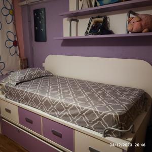 uma cama num quarto com paredes roxas em Habitación individual con baño privado en casa particular em Madri