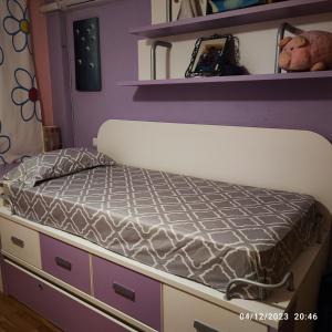 a bed in a bedroom with purple walls at Habitación individual con baño privado en casa particular in Madrid