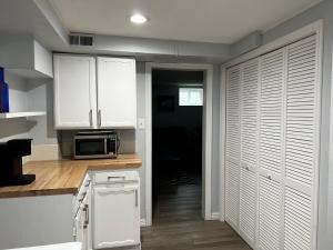 una cucina con mobili bianchi e un forno a microonde di Guest Suite in Lafayette a Lafayette