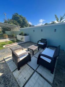 eine Terrasse mit 2 Stühlen und einem Tisch in der Unterkunft Playa y Campo Apartment #2 in Isabela