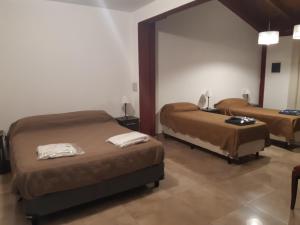 a bedroom with two beds and a mirror at DEPARTAMENTO PLANTA BAJA in Villa Nueva