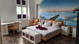 Schlafzimmer mit einem Bett mit Wandgemälde in der Unterkunft Pension Domke in Ahlbeck