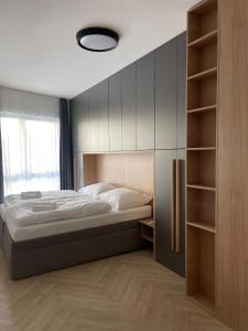 a bedroom with a bed and a book shelf at 8 Apartment BREZY VYSOKÉ TATRY in Stará Lesná