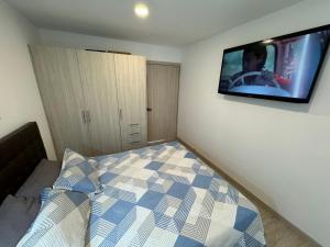 a bedroom with a bed with a tv on the wall at Suite Nueva en Salinas - Chipipe, en conjunto privado in Salinas