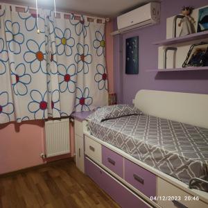 um pequeno quarto com uma cama e uma cortina em Habitación individual con baño privado en casa particular em Madri