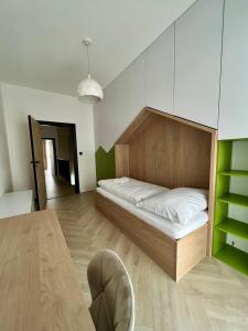 a bedroom with a bed with a wooden headboard at 8 Apartment BREZY VYSOKÉ TATRY in Stará Lesná