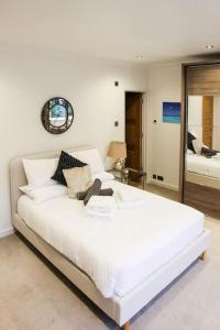 a large white bed in a room with a mirror at Hot Tub/Football Court/Sleeps 12/Luxury Villa in Parkstone