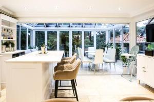 an open kitchen and dining room with a conservatory at Hot Tub/Football Court/Sleeps 12/Luxury Villa in Parkstone