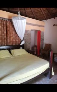 a bedroom with a bed and a chandelier at Evergreen Eco Lodge Retreat in Tujering