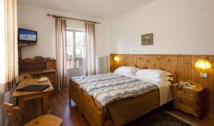 Säng eller sängar i ett rum på Hotel Bellaria - Cortina d'Ampezzo