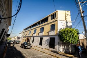 a building on a street with a car parked next to it at Hotel Corregidor by Cassana in Arequipa