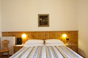 A bed or beds in a room at Hotel Bellaria - Cortina d'Ampezzo