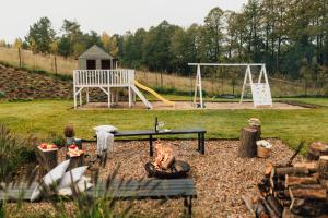 a park with a playground with a table and a swing at Kalwa Lake House - dom nad jeziorem z prywatnym pomostem i jacuzzi oraz sprzętem wodnym in Pasym