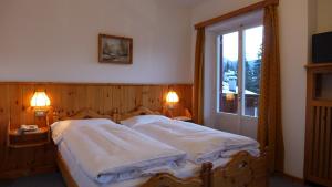 A bed or beds in a room at Hotel Bellaria - Cortina d'Ampezzo