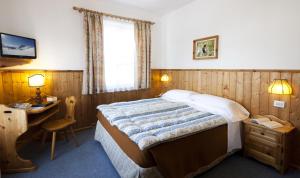A bed or beds in a room at Hotel Bellaria - Cortina d'Ampezzo