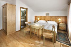 A bed or beds in a room at Hotel Bellaria - Cortina d'Ampezzo