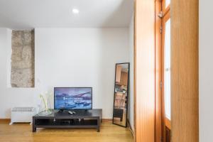 uma sala de estar com televisão e espelho em GuestReady - Daisy Boutique no Porto