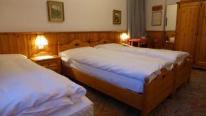 A bed or beds in a room at Hotel Bellaria - Cortina d'Ampezzo