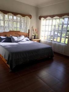 a bedroom with a large bed and windows at LA CASA DE JOSÉ Excelente en Laguna de Sanchez in Laguna de Sánchez