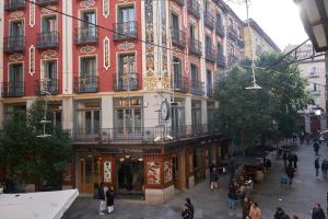 eine Gruppe von Menschen, die vor einem Gebäude spazieren in der Unterkunft Lovely Apartments - Alójate en el corazón de Madrid in Madrid