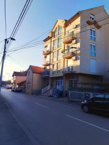 a building on the side of a street with a car at Apartman Centar in Požarevac