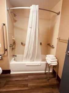 a bathroom with a bath tub with a shower curtain at FairBridge Inn Express Nyack in Nyack