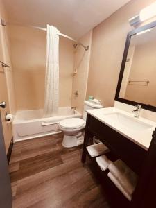 a bathroom with a toilet and a tub and a sink at FairBridge Inn Express Nyack in Nyack