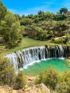 uma cascata com uma piscina de água em frente em Cozy house, Bespén, Huesca 