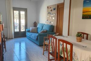 uma sala de estar com um sofá azul e uma mesa em Cozy house, Bespén, Huesca 