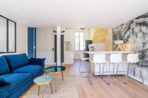 uma sala de estar com um sofá azul e uma mesa em Appartement entier haut de gamme em Bordeaux