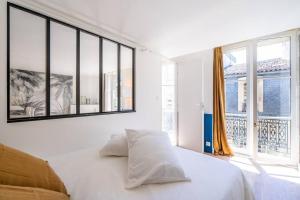 - une chambre avec un lit blanc et de grandes fenêtres dans l'établissement Appartement entier haut de gamme, à Bordeaux