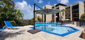 een zwembad in een resort met een stoel en een parasol bij Moon Bay A410 in Key Largo