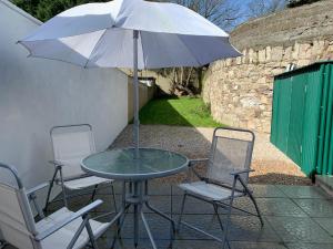 una mesa con 2 sillas y una sombrilla en el patio en Seventy Eight, en Wexford