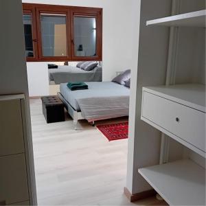 1 dormitorio con 1 cama y 1 habitación con espejo en Bilocale Marylin vicino all'aeroporto en Bolonia