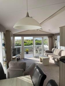a living room with a couch and chairs and a television at Harbour Escape - Church Farm in Pagham