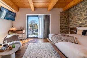een slaapkamer met een groot bed en een woonkamer bij Boutique Via Roma 33 -Tuscany Experience - Hotel & Spa in Stia
