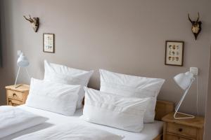 um quarto com uma cama com almofadas brancas em Wailtl Hotel em Dorfen