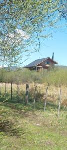a fence in front of a house in a field at La Pancora del Futa in Los Cipreses