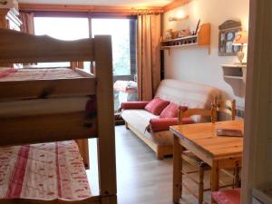 a living room with a bunk bed and a couch at Studio cosy skis aux pieds avec balcon et piscine chauffée - FR-1-267-205 in Le Corbier +10 photos
