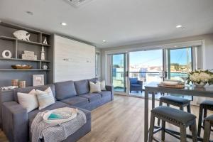 un soggiorno con divano blu e tavolo di NEW Luxury Beach Home I 3BR I Balcony I Firepit a San Diego