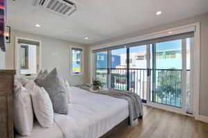 a bedroom with a large bed and a large window at NEW Luxury Beach Home I 3BR I Balcony I Firepit in San Diego