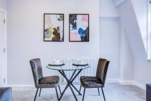 una sala da pranzo con tavolo e 2 sedie di Artsy Serviced Apartments - Victoria a Londra