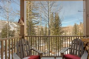 2 Stühle auf einer Veranda mit Bergblick in der Unterkunft Saddleridge Villas #3 in Beaver Creek